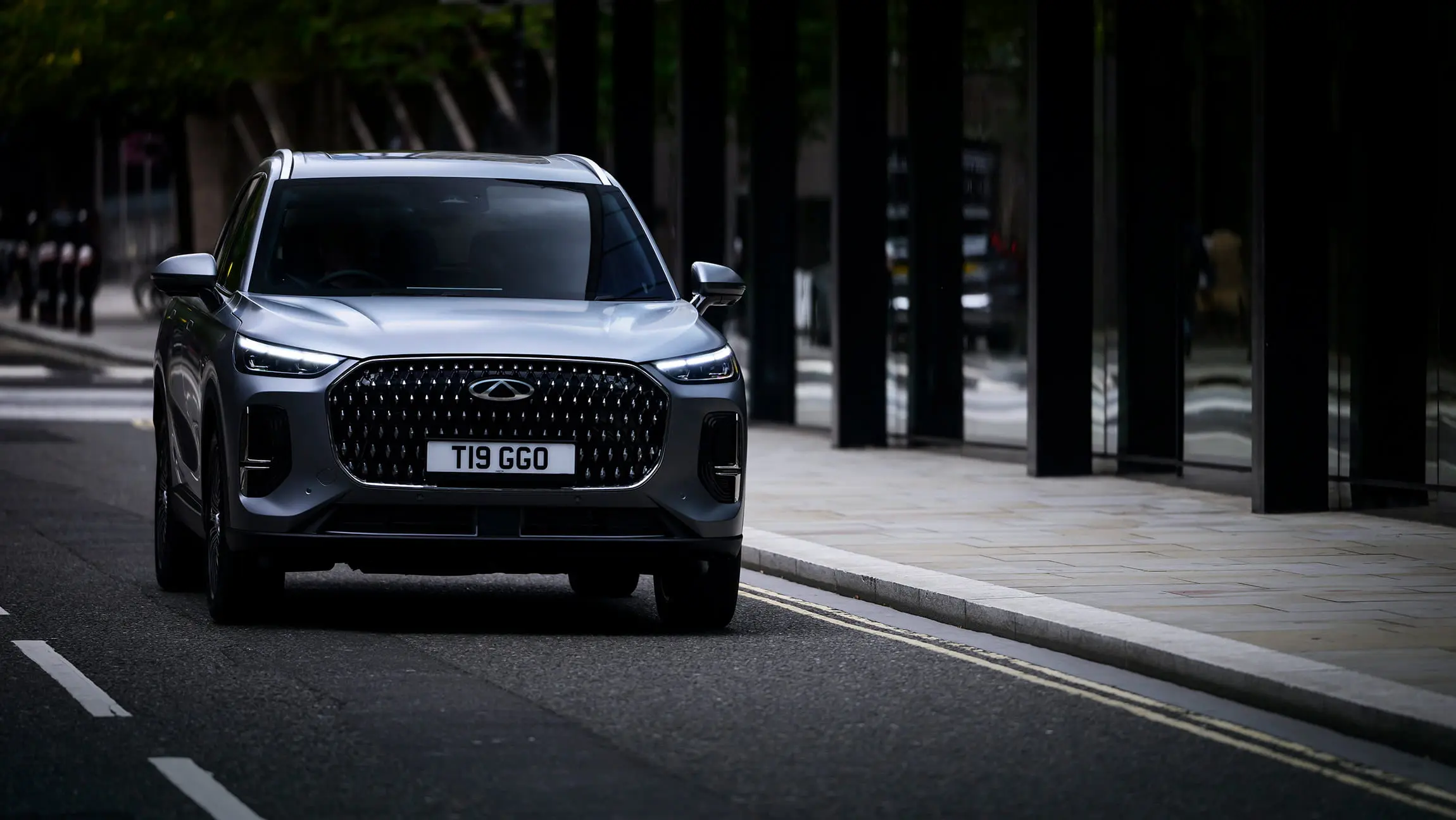 Chery Tiggo 9 CSH SUV in matte grey finish, driving on an urban street 